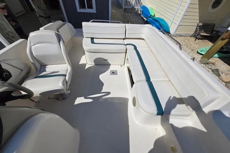 Slide: The Image of 1999 Bayliner 2459 Rendezvous DX/LX boat interior with white seating and teal accents. - 13