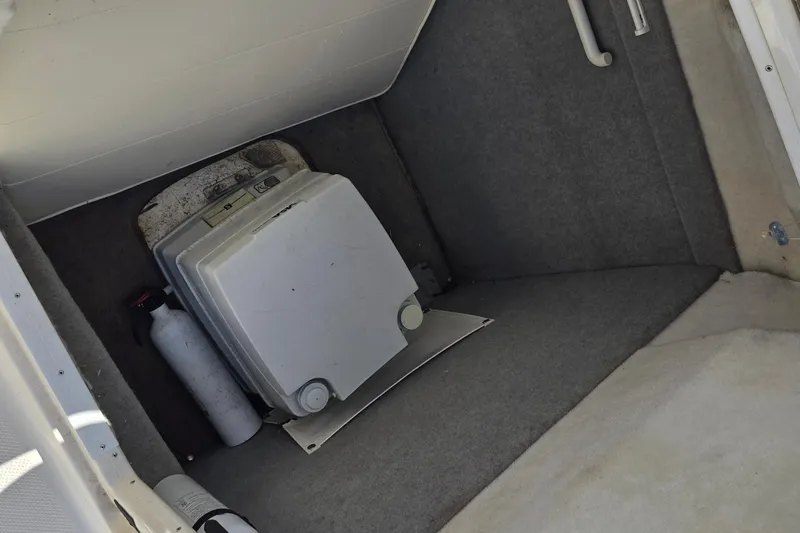 Slide: The Image of Interior of 1999 Bayliner 2459 Rendezvous DX/LX with portable toilet and fire extinguisher. - 17