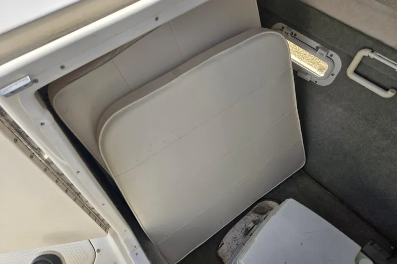 Slide: The Image of 1999 Bayliner 2459 Rendezvous DX/LX interior storage with cushions and window. - 18