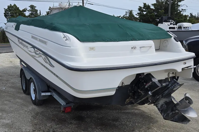 Slide: The Image of 1999 Bayliner 2459 Rendezvous DX/LX boat with green cover on trailer. - 2