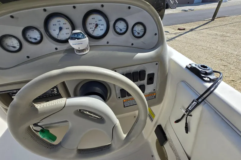 Slide: The Image of 1999 Bayliner 2459 Rendezvous DX/LX boat dashboard with steering wheel and gauges. - 23