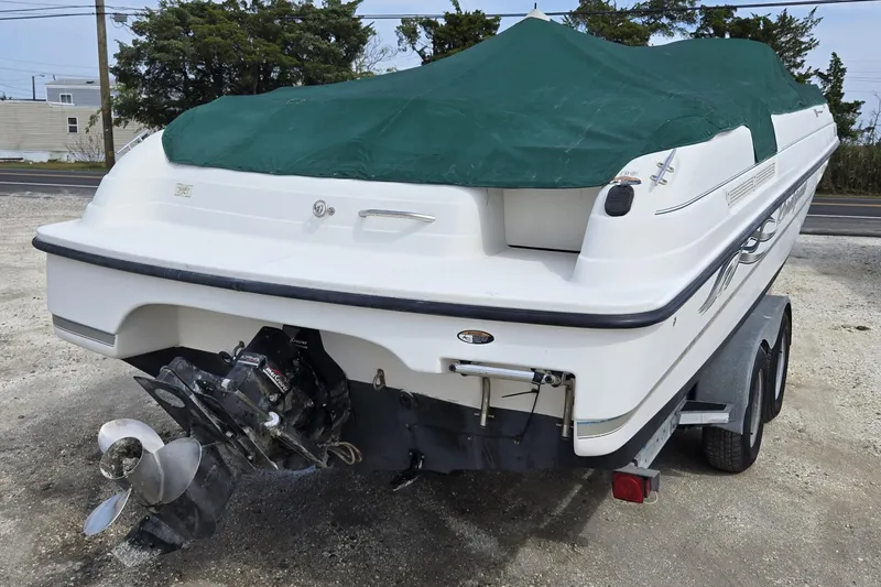 Slide: The Image of 1999 Bayliner 2459 Rendezvous DX/LX boat with green cover on trailer, rear view. - 27