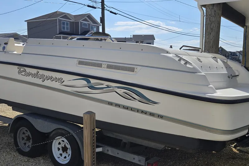 Slide: The Image of 1999 Bayliner 2459 Rendezvous DX/LX boat on trailer, parked outdoors. - 28
