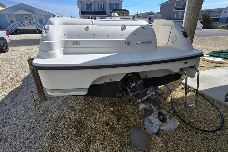 Slide: The Image of 1999 Bayliner 2459 Rendezvous DX/LX boat on gravel, showing rear view and propeller. - 29