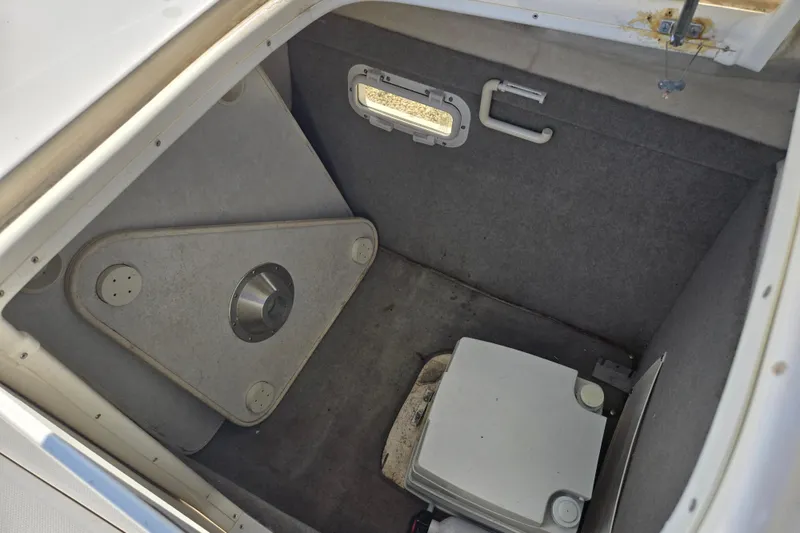 Slide: The Image of 1999 Bayliner 2459 Rendezvous DX/LX boat interior storage compartment with portable toilet. - 5