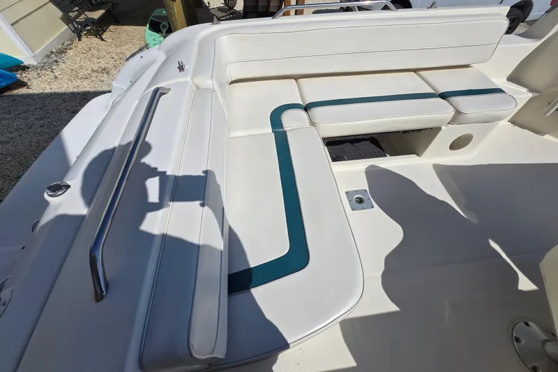 Slide: The Image of 1999 Bayliner 2459 Rendezvous DX/LX boat interior with white and teal seating. - 8