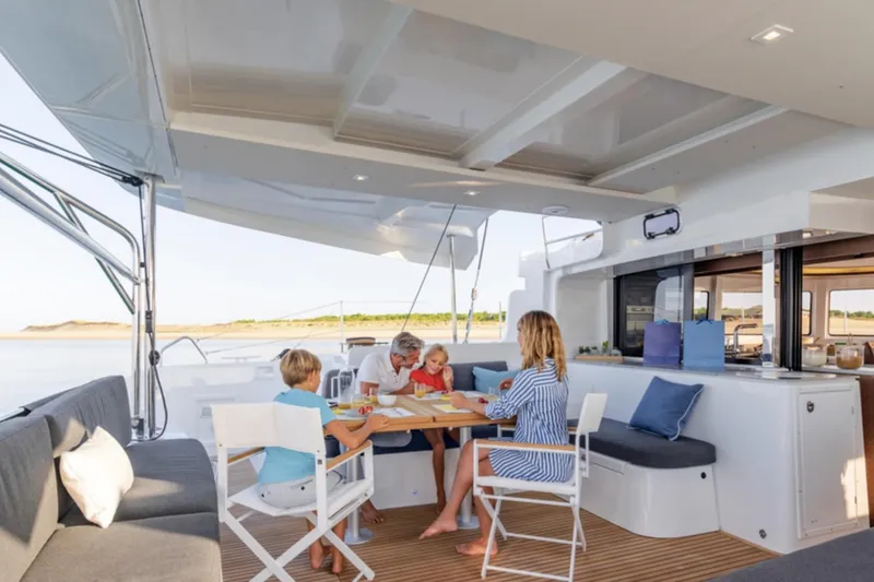 Slide: The Image of Family dining on Lagoon 46 yacht, 2026 model, enjoying a meal on deck. - 10