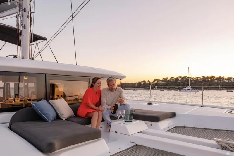 Slide: The Image of Couple enjoying sunset on Lagoon 46 catamaran, 2026 model, with scenic coastal view. - 12