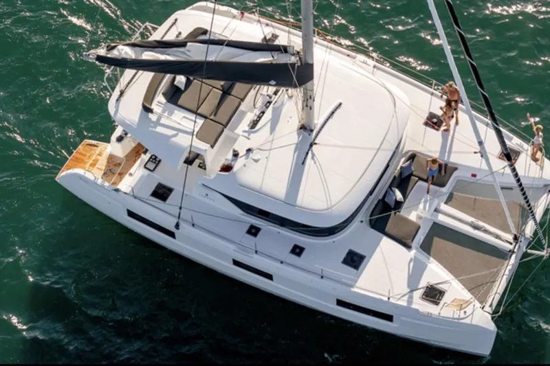 Slide: The Image of Aerial view of 2026 Lagoon 46 ICONIC catamaran sailing with passengers on deck. - 14