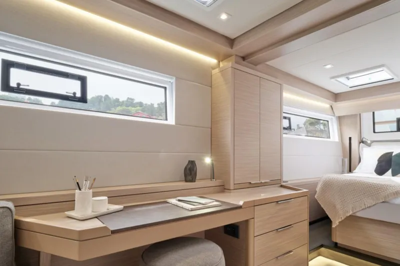 Slide: The Image of Luxurious interior of 2026 Lagoon 51 yacht with modern desk and cozy bed. - 9