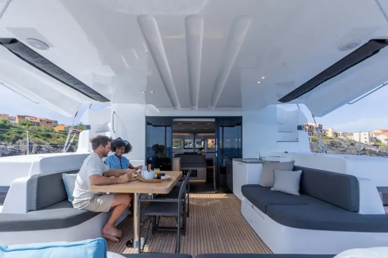 Slide: The Image of Couple dining on Lagoon 51 ICONIC yacht, 2026 model, with modern interior and scenic view. - 3