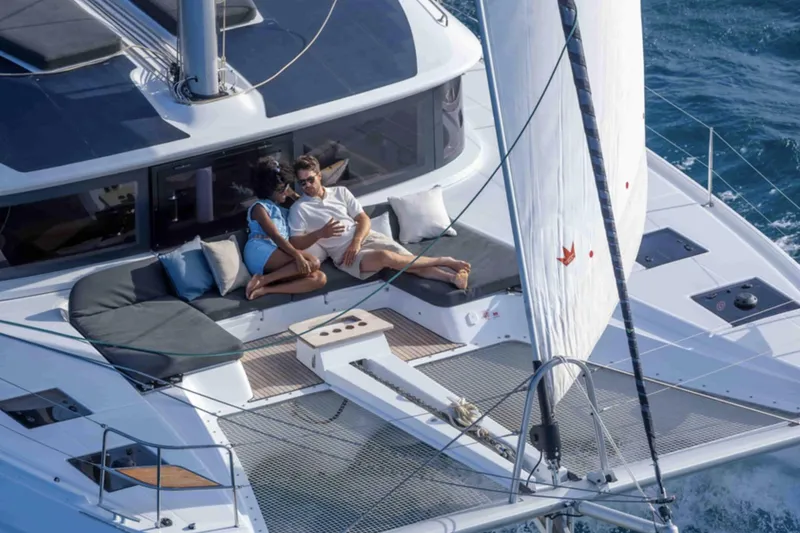 Slide: The Image of Couple relaxing on Lagoon 51 ICONIC yacht, 2026 model, sailing on open water. - 4