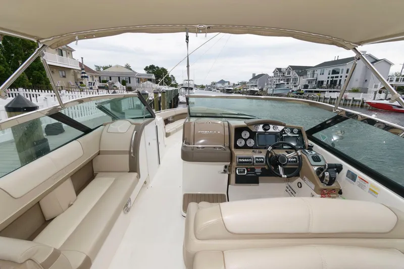 Slide: The Image of 2014 Formula 350 Crossover Bowrider interior with helm, seating, and waterfront view. - 5