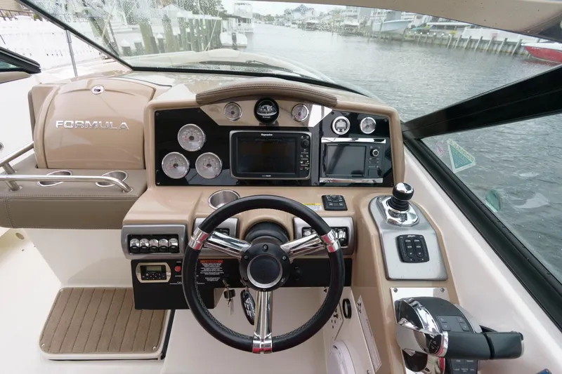 Slide: The Image of 2014 Formula 350 Crossover Bowrider helm with steering wheel and navigation controls. - 8