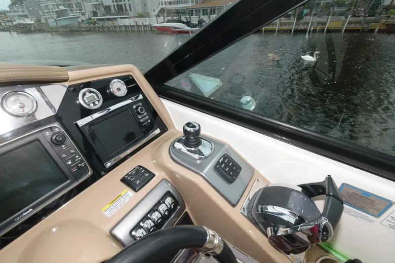 Slide: The Image of 2014 Formula 350 Crossover Bowrider dashboard with navigation controls, overlooking a marina. - 9