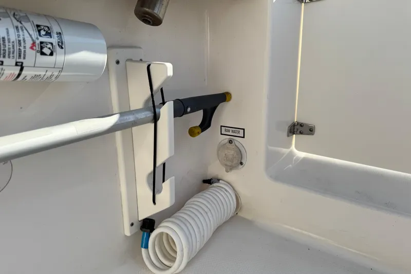 Slide: The Image of 2015 Pursuit DC 265 Dual Console boat interior with raw water access and storage. - 11