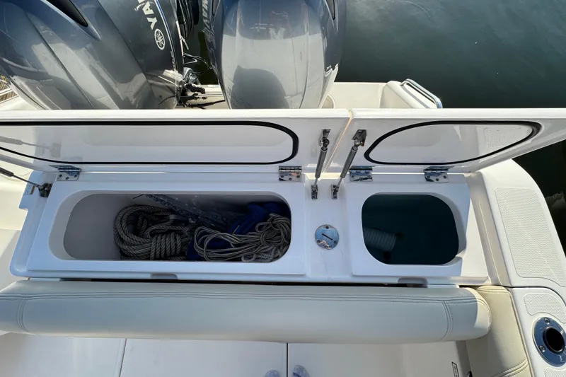 Slide: The Image of 2015 Pursuit DC 265 Dual Console boat storage compartments with ropes and equipment. - 12