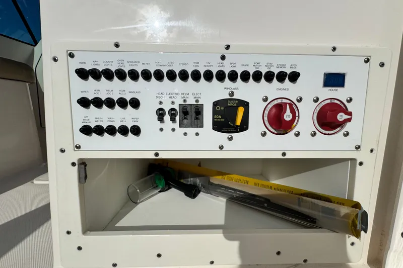Slide: The Image of Control panel of a 2015 Pursuit DC 265 Dual Console boat with switches and storage compartment. - 13