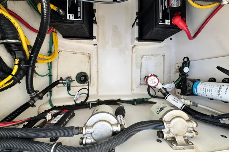 Slide: The Image of 2015 Pursuit DC 265 Dual Console boat engine compartment with batteries and wiring. - 15