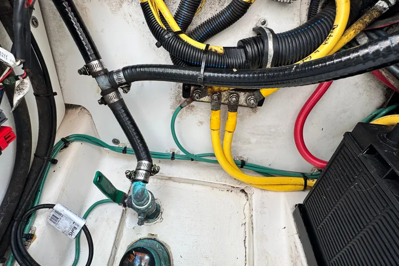 Slide: The Image of Wiring and hoses in a 2015 Pursuit DC 265 Dual Console boat engine compartment. - 18
