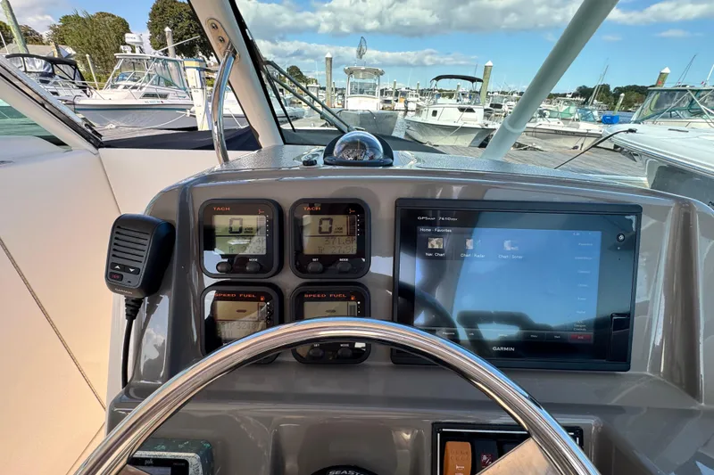 Slide: The Image of 2015 Pursuit DC 265 Dual Console dashboard with Garmin GPS and control gauges at marina. - 20