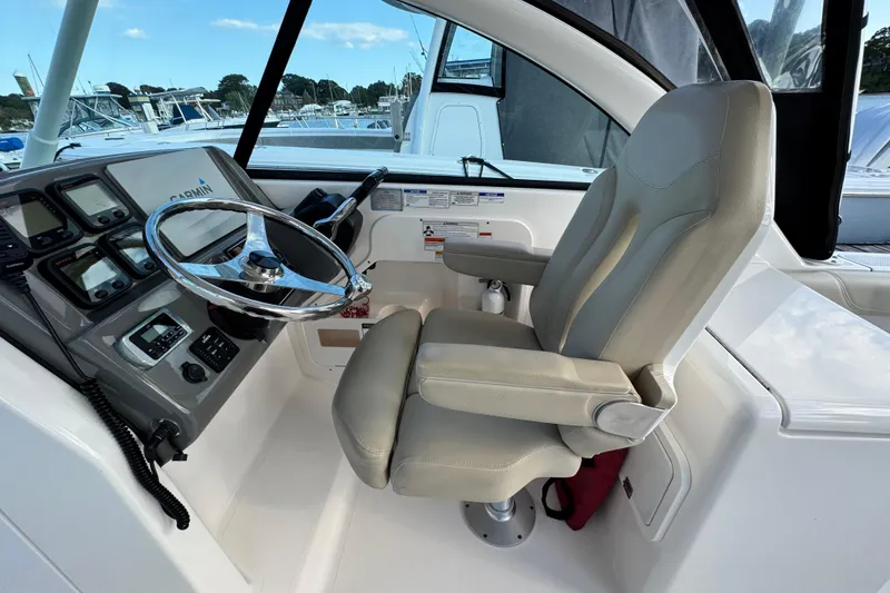Slide: The Image of 2015 Pursuit DC 265 Dual Console boat cockpit with steering wheel and captain's chair. - 22