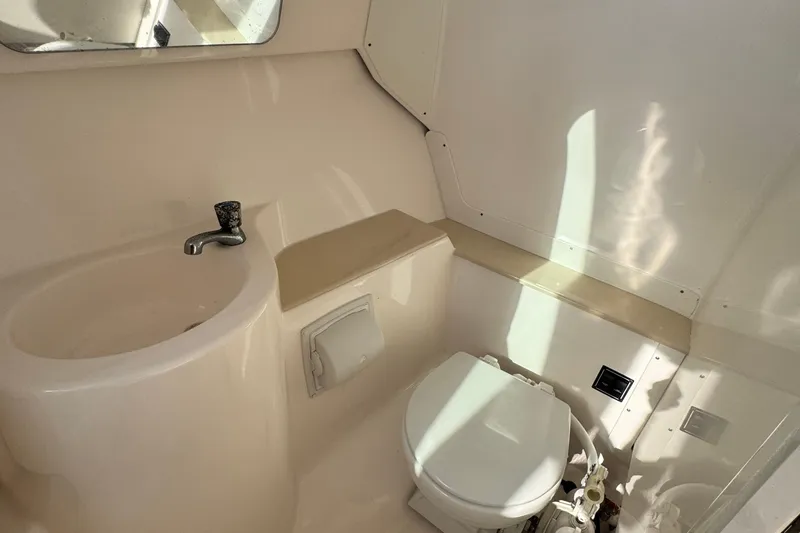 Slide: The Image of 2015 Pursuit DC 265 Dual Console boat bathroom with sink and toilet. - 23
