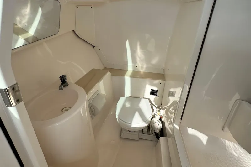 Slide: The Image of 2015 Pursuit DC 265 Dual Console boat bathroom with sink and toilet. - 24