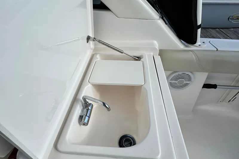 Slide: The Image of 2015 Pursuit DC 265 Dual Console boat sink with faucet and storage compartment. - 25