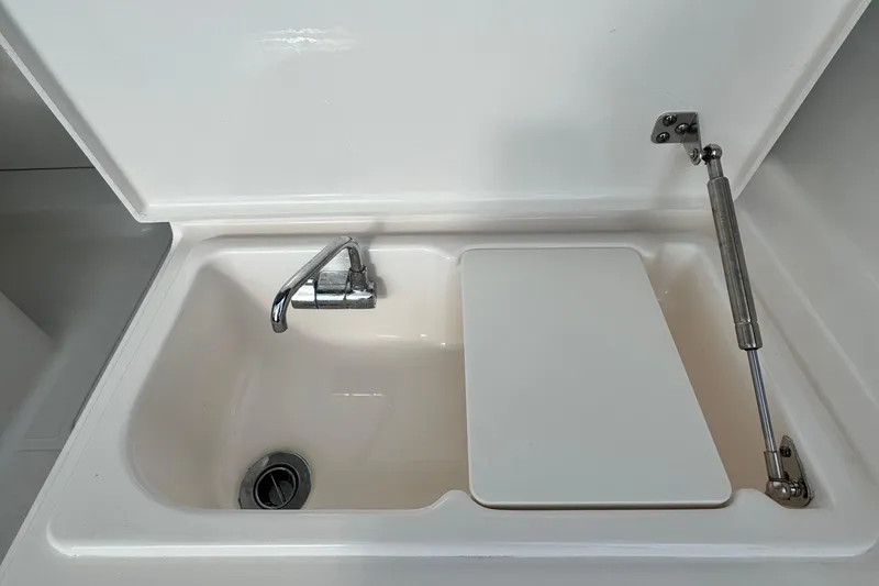 Slide: The Image of 2015 Pursuit DC 265 Dual Console boat sink with faucet and cover. - 26