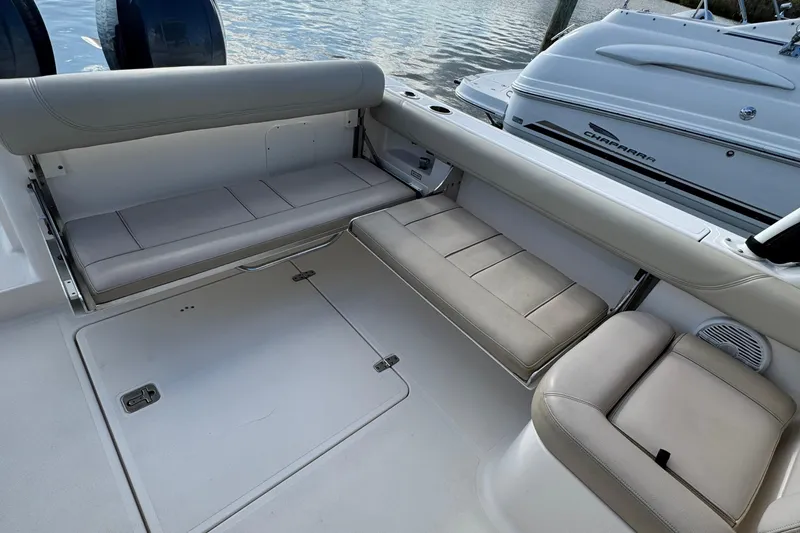 Slide: The Image of 2015 Pursuit DC 265 Dual Console boat interior with cushioned seating and storage compartments. - 30