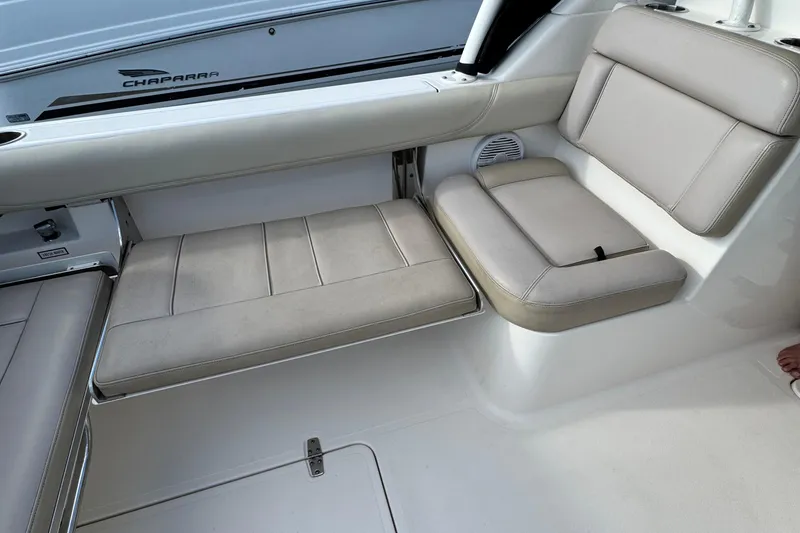 Slide: The Image of 2015 Pursuit DC 265 Dual Console boat interior with beige seating and storage. - 31