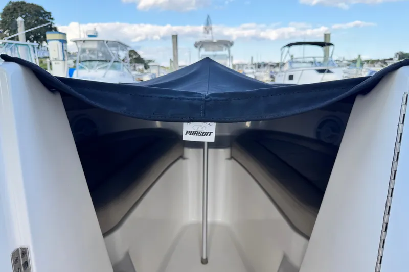 Slide: The Image of 2015 Pursuit DC 265 Dual Console boat interior with cover, docked at marina. - 35