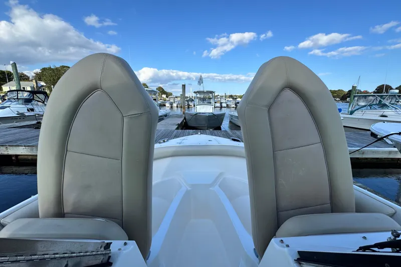 Slide: The Image of 2015 Pursuit DC 265 Dual Console boat seats at marina, clear sky background. - 36