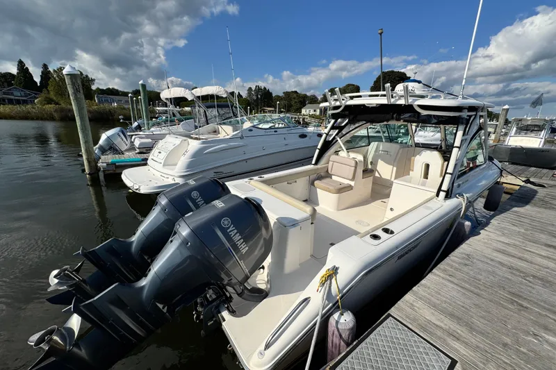 Slide: The Image of 2015 Pursuit DC 265 Dual Console boat docked with Yamaha engines. - 4