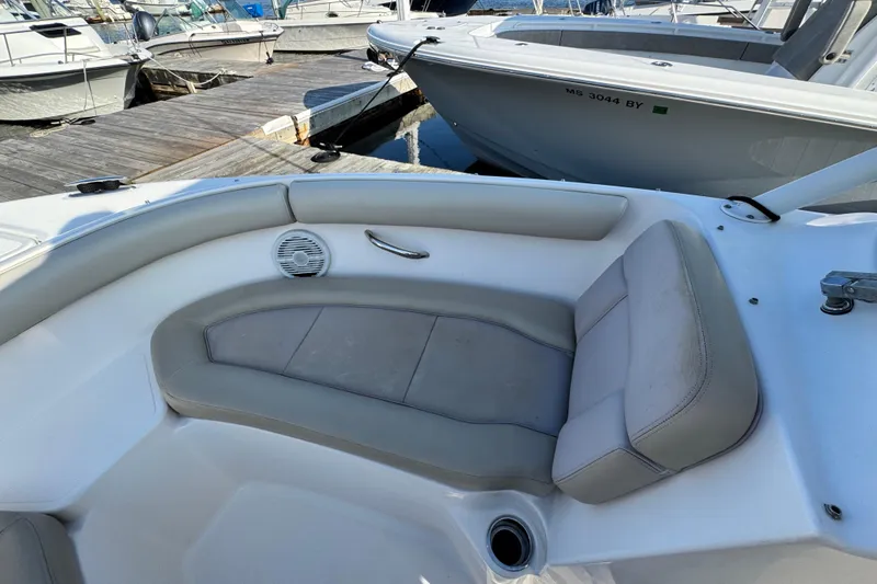Slide: The Image of 2015 Pursuit DC 265 Dual Console boat interior with cushioned seating at dock. - 43