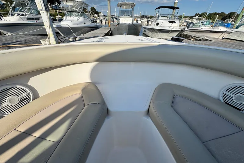 Slide: The Image of 2015 Pursuit DC 265 Dual Console boat interior with cushioned seating at marina. - 44
