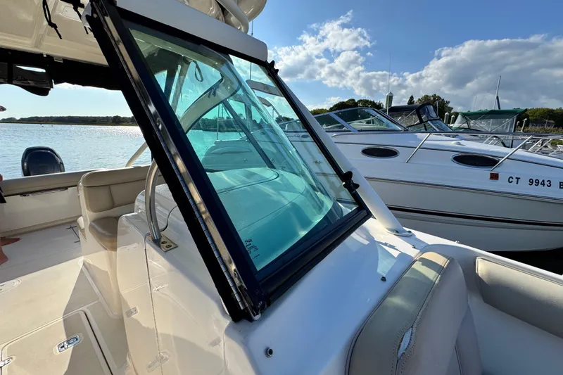 Slide: The Image of 2015 Pursuit DC 265 Dual Console boat docked under a sunny sky. - 49