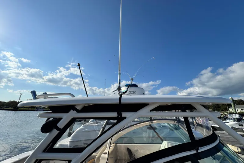 Slide: The Image of 2015 Pursuit DC 265 Dual Console boat docked under a clear blue sky. - 50