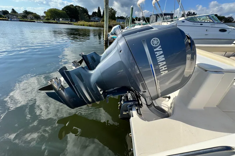 Slide: The Image of 2015 Pursuit DC 265 Dual Console with Yamaha outboard motor docked by the water. - 6