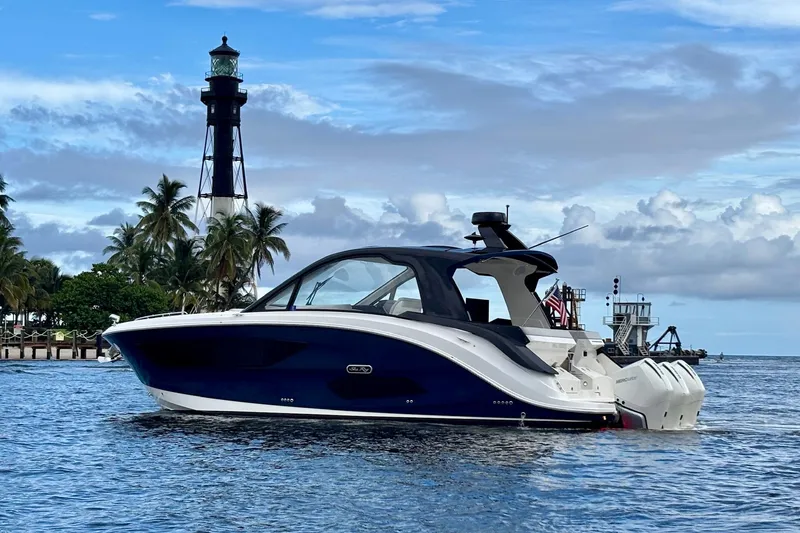 The Image of 2022 Sea Ray Sundancer 370 Outboard near lighthouse, calm waters, and palm trees. - 0