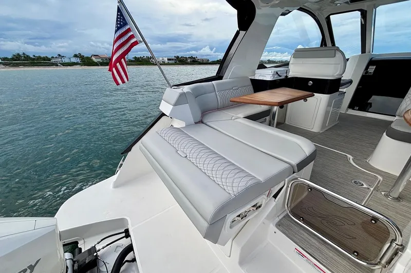 Slide: The Image of 2022 Sea Ray Sundancer 370 Outboard interior with seating, table, and American flag. - 29