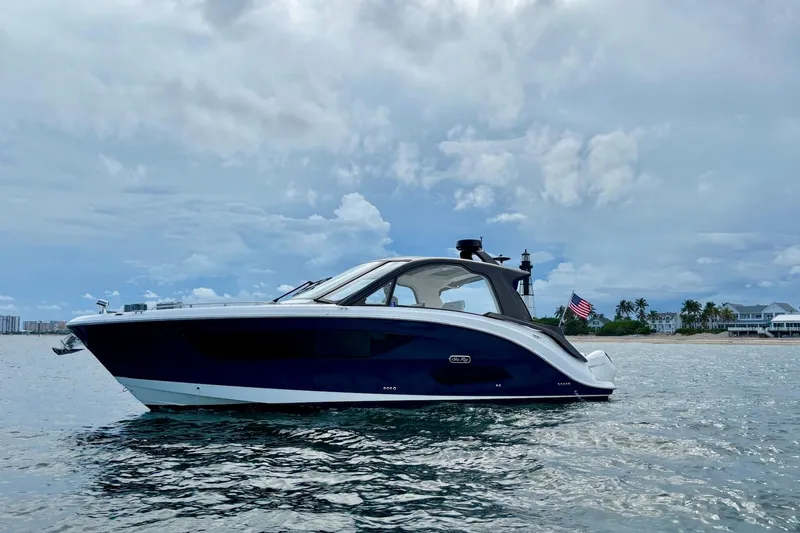 Slide: The Image of 2022 Sea Ray Sundancer 370 Outboard cruising on calm waters under a cloudy sky. - 3