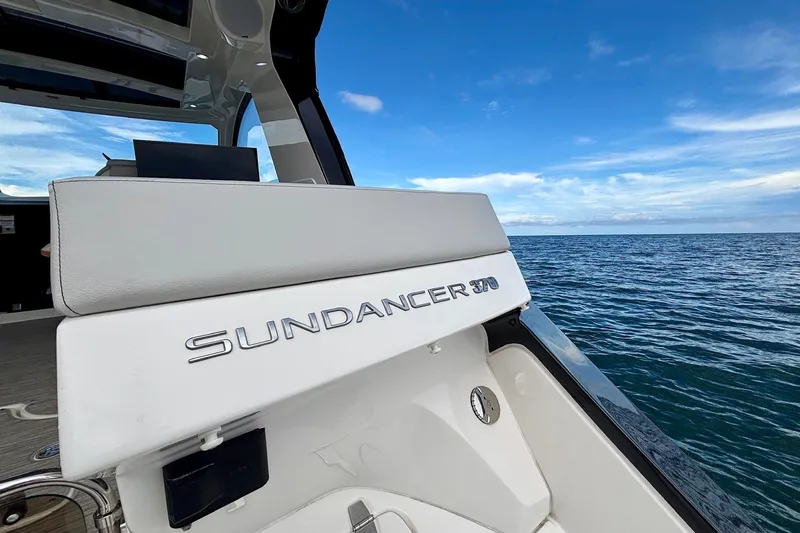 Slide: The Image of 2022 Sea Ray Sundancer 370 Outboard boat on open water under a clear blue sky. - 31
