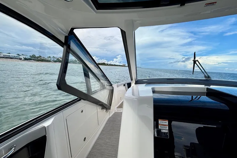 Slide: The Image of 2022 Sea Ray Sundancer 370 Outboard interior with open window, ocean view, and sleek design. - 32