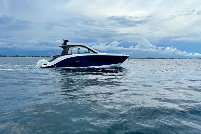 Slide: The Image of 2022 Sea Ray Sundancer 370 Outboard cruising on open water under a cloudy sky. - 33
