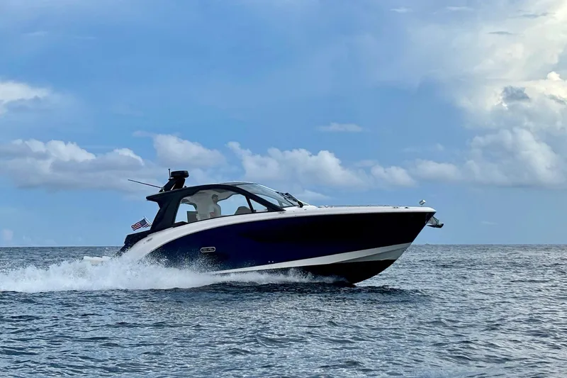 Slide: The Image of 2022 Sea Ray Sundancer 370 Outboard cruising on open water under a blue sky. - 34
