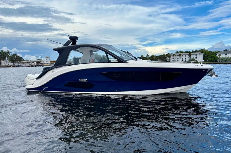 Slide: The Image of 2022 Sea Ray Sundancer 370 Outboard cruising on calm waters under a partly cloudy sky. - 38