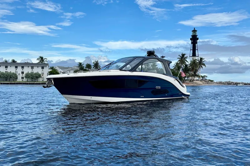 Slide: The Image of 2022 Sea Ray Sundancer 370 Outboard cruising near a lighthouse on a sunny day. - 7
