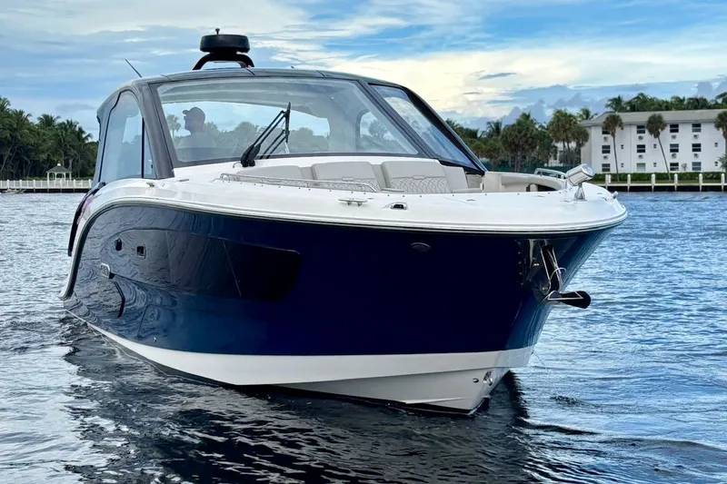 Slide: The Image of 2022 Sea Ray Sundancer 370 Outboard cruising on calm water, with a scenic backdrop. - 8